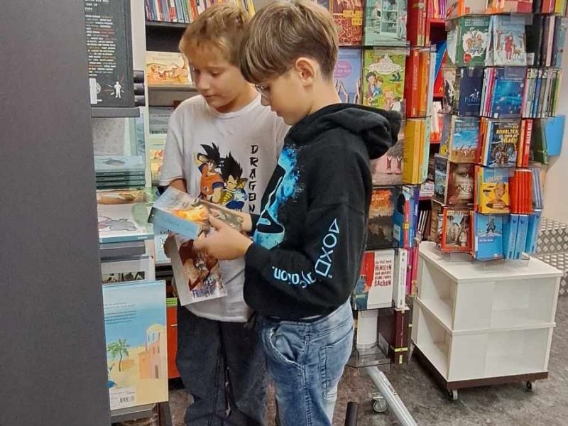 Slika 3: Mattia in Noah pri brskanju med zanimivimi knjigami